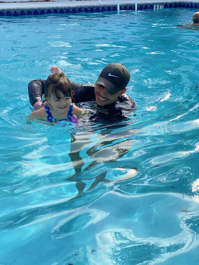 Parent holding a child in the water during a lesson
