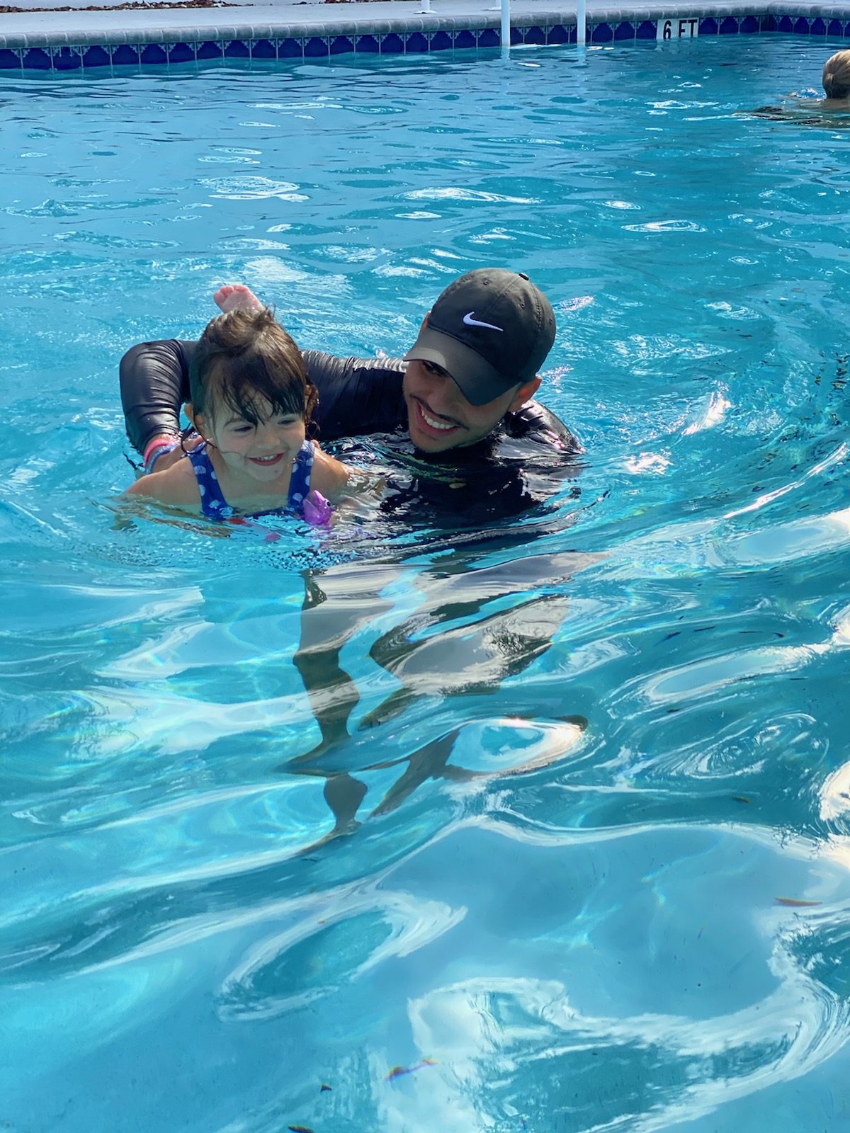 Parent holding a child in the water during a lesson