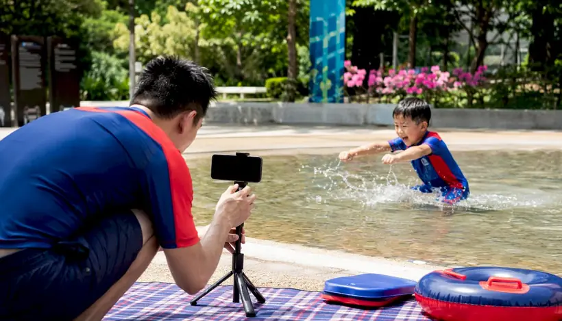 Parent recording child's swim arm practice at home