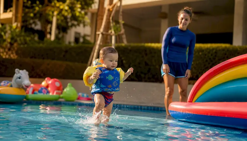 Infant independently swimming toward pool edge