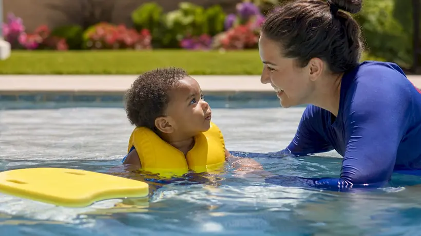 Toddler receiving swim lesson assistance