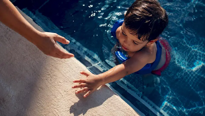 Caregiver supervising child in pool