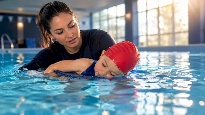 Instructor guiding toddler survival swim practice