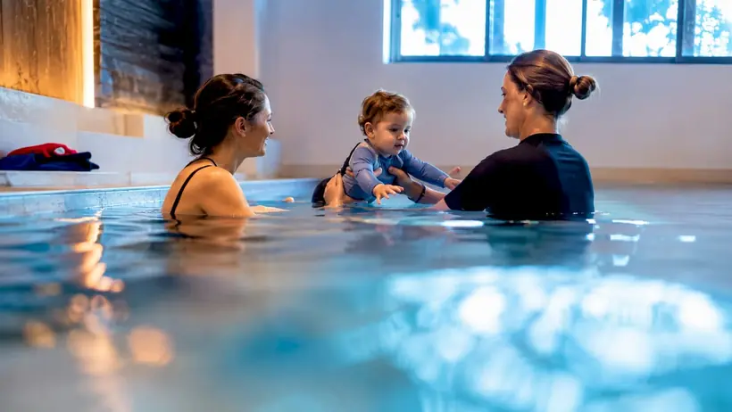 Instructor guiding toddler winter swim lesson