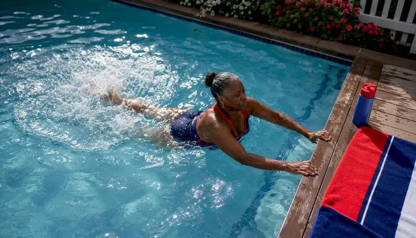 Woman kicking at edge of backyard pool