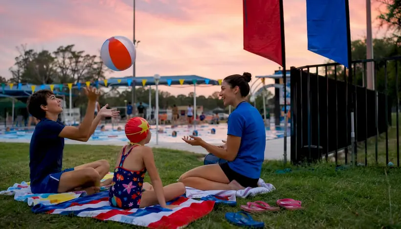 Swim coach discussing lesson formats with siblings