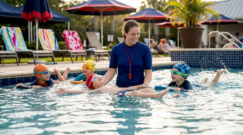 Small group swim lesson with instructor and children in pool