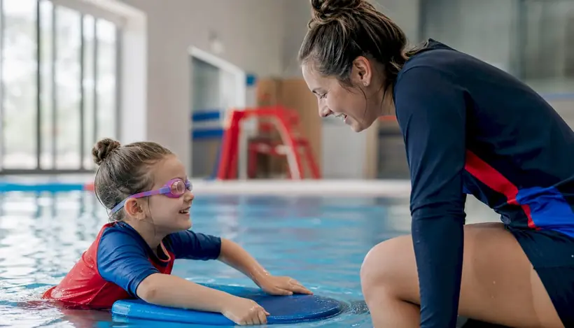 Instructor observing children interacting in pool