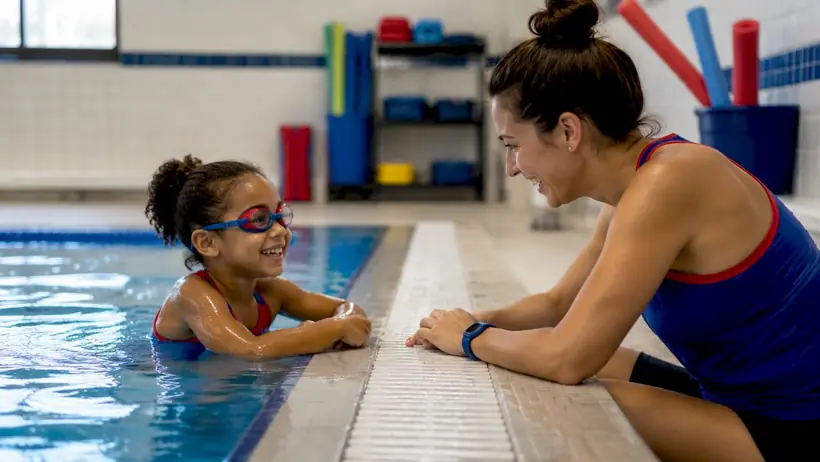 Child receiving swim lesson guidance in pool